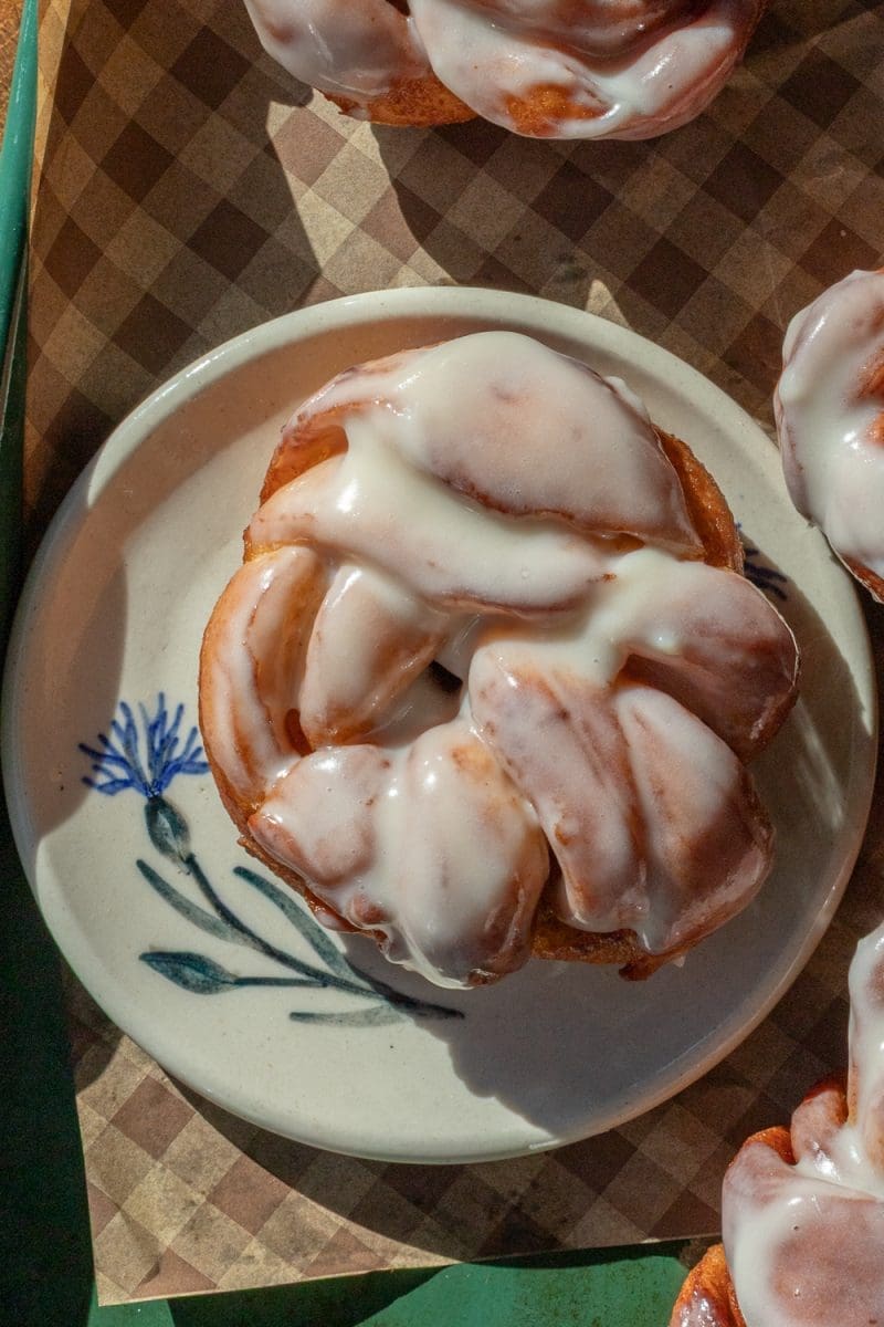 Close up of one of the cinnamon roll donuts on a plate.