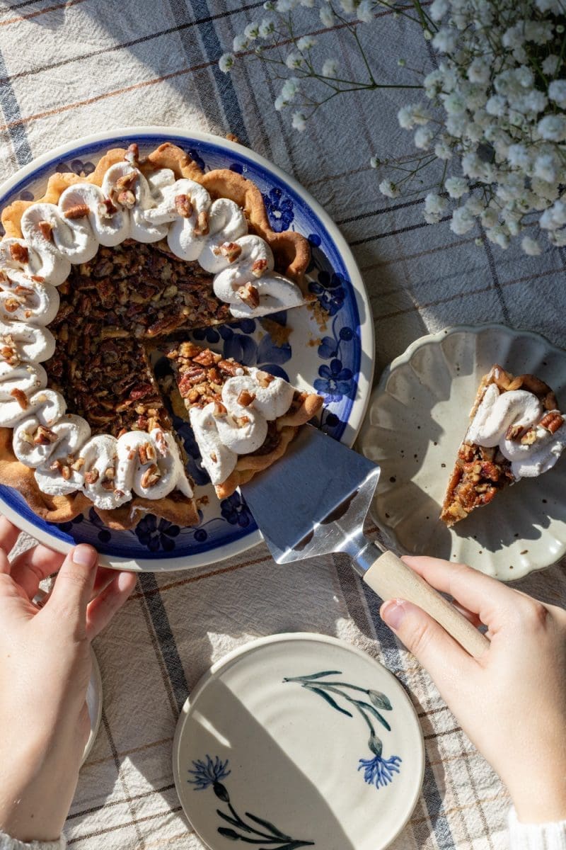 Pulling a slice of maple pecan pie out.