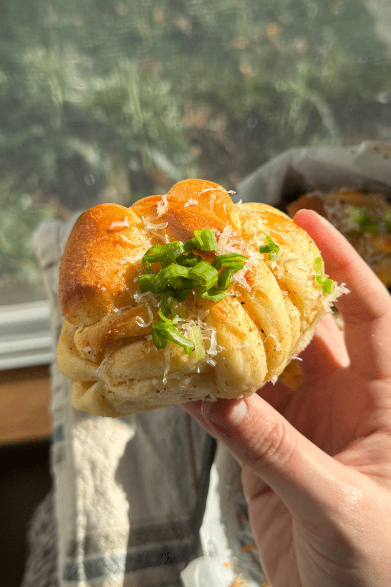 Holding up one of the brown butter garlic knots.