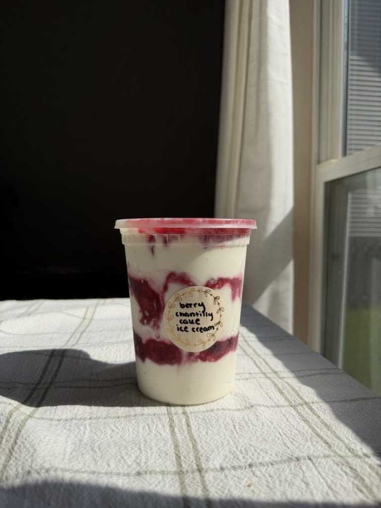 The berry chantilly cake ice cream in a deli container